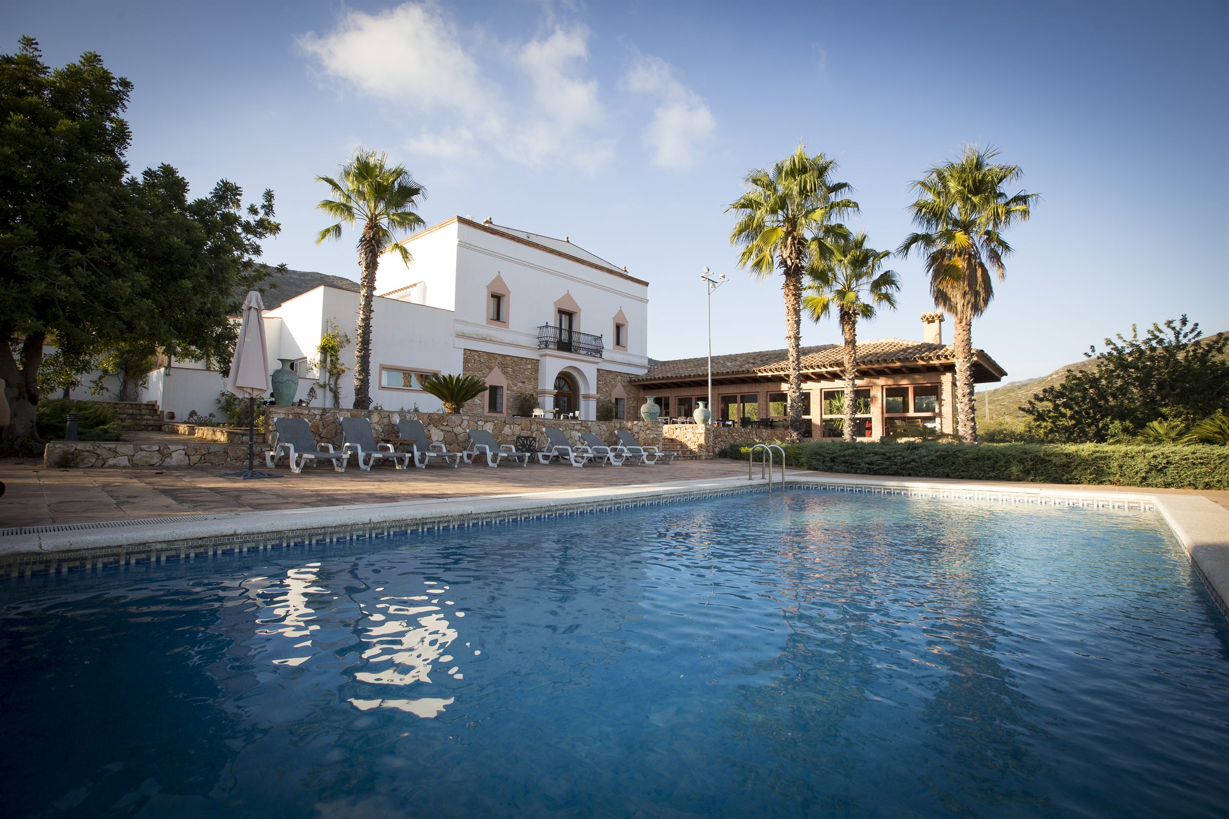 La masía y la piscina al atardecer